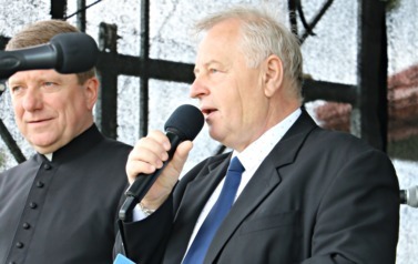 Konferansjer w ciemnym garniturze. 