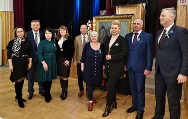 Pamiątkowe zdjęcie gości przy obrazie I. Łukasiewicza 