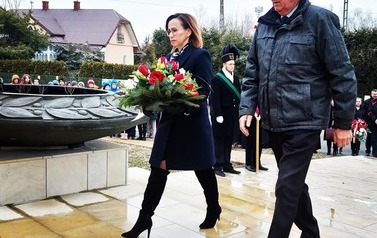 Przedstawiciele władzy powiatowej składają biało-czerwoną wiązankę przy obelisku. 