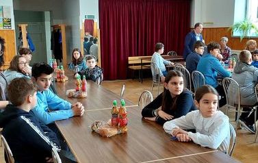 Młodzież szkolna biorąca udział w turnieju. Uczniowie siedzą przy stoliku.