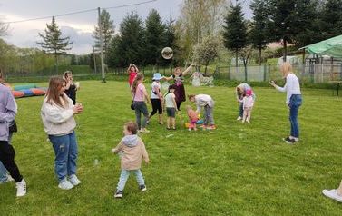 Grupa dzieci, kt&oacute;re bawią się na sztucznej murawie Kompleksu Boisk Sportowych w Chork&oacute;wce. 