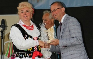 W&oacute;jt wręcza podziękowanie kobiecie ubranej w str&oacute;j ludowy. 