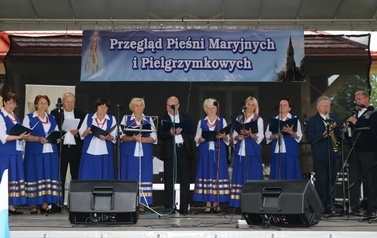 Zesp&oacute;ł śpiewaczy w niebieskich strojach. Kobiety i mężczyźni. 