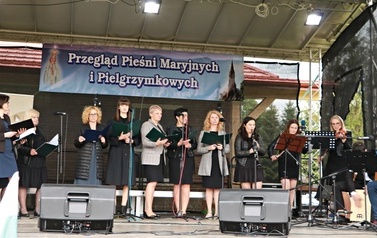 Schola mieszana. Kobiety oraz mężczyźni grający na instrumentach. 
