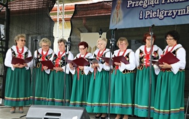 Zesp&oacute;ł Chorkowianie w tradycyjnych ludowych strojach. Zar&oacute;wno kobiety oraz mężczyźni. Występ na scenie podczas Gminnej Wigilii. 