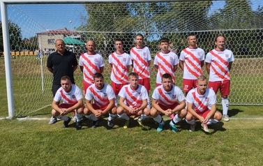 Zdjęcie drużyny piłkarskiej w buało-czerwonych strojach. 