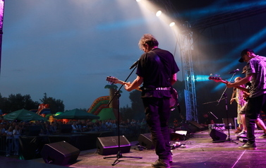 Zesp&oacute;ł KSU na scenie. Czterech mężczyzn oraz dwie kobiety. Każda z os&oacute;b ze swoim instrumentem muzycznym: gitarą, fletem, harfą, perkusją oraz lirą. 