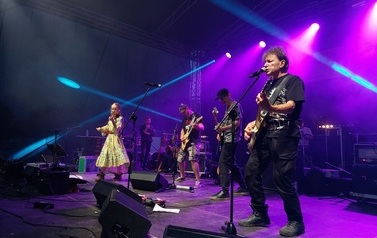 Zesp&oacute;ł KSU na scenie. Czterech mężczyzn oraz dwie kobiety. Każda z os&oacute;b ze swoim instrumentem muzycznym: gitarą, fletem, harfą, perkusją oraz lirą. 