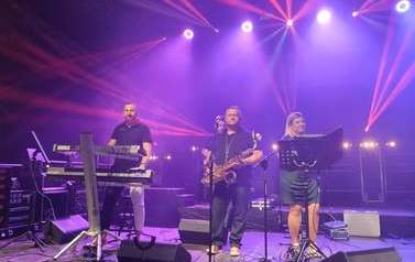 Zesp&oacute;ł KSU na scenie. Czterech mężczyzn oraz dwie kobiety. Każda z os&oacute;b ze swoim instrumentem muzycznym: gitarą, fletem, harfą, perkusją oraz lirą. 