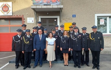 Zdjęcie zaproszonych gości. Mężczyźni w mundurach oraz jedna kobieta ubrana na jasno. 