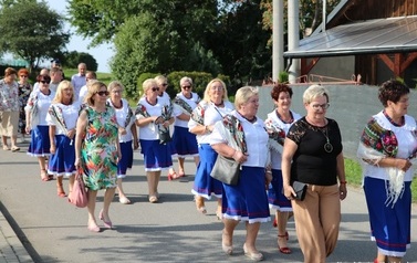 Przemarsz uczestnik&oacute;w spotkania. Jako pierwsze idą mażoretki, następnie orkiestra dęta, zaproszeni goście i gospodarze uroczystości. 
