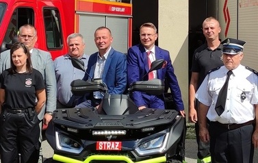 Zdjęcie czarno-ż&oacute;łtego quada na rzecz OSP Kobylany. Na zdjęciu przedstawiciele władzy oraz jednostki OSP Kobylany. 