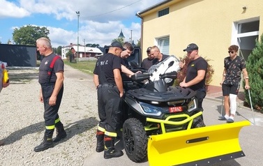 Zdjęcie czarno-ż&oacute;łtego quada na rzecz OSP Kobylany. Na zdjęciu przedstawiciele władzy oraz jednostki OSP Kobylany. 