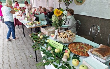 Kącik kulinarny przygotowany dla uczestnik&oacute;w spotkania. Na stoliku drożdżowe wypieki, smalec, szarlotka i inne przysmaki. 