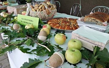 Kącik kulinarny przygotowany dla uczestnik&oacute;w spotkania. Na stoliku drożdżowe wypieki, smalec, szarlotka i inne przysmaki. 