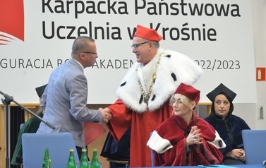 Na zdjęciu w&oacute;jt gminy ściska dłoń rektorowi uczelni podczas inauguracji roku szkolnego. 
