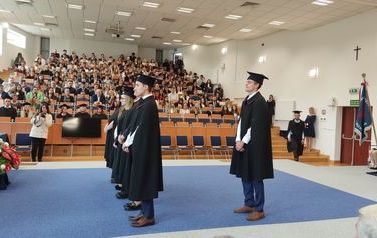 Wyr&oacute;żnieni studenci w uroczystych ubraniach. 