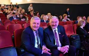Dw&oacute;ch mężczyzn siedzących na widowni. 