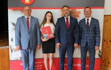 Zdjęcie ucznia z przedstawicielami gminy i dyrektorem. 
