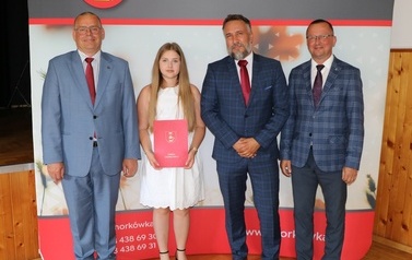 Zdjęcie ucznia z przedstawicielami gminy i dyrektorem. 