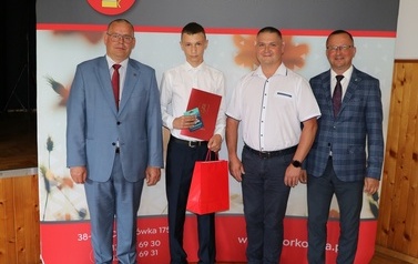 Zdjęcie ucznia z przedstawicielami gminy i dyrektorem. 