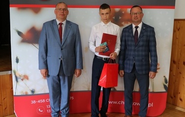 Zdjęcie ucznia z przedstawicielami gminy i dyrektorem. 