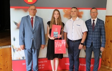 Zdjęcie ucznia z przedstawicielami gminy i dyrektorem. 