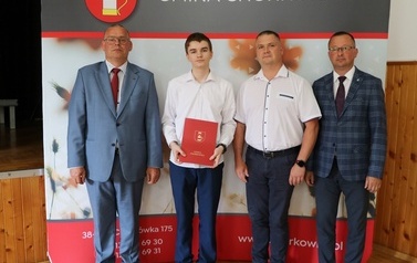 Zdjęcie ucznia z przedstawicielami gminy i dyrektorem. 