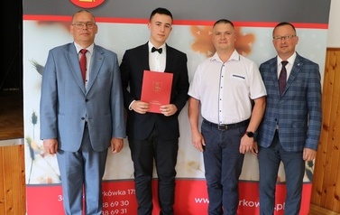 Zdjęcie ucznia z przedstawicielami gminy i dyrektorem. 