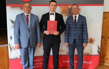 Zdjęcie ucznia z przedstawicielami gminy i dyrektorem. 