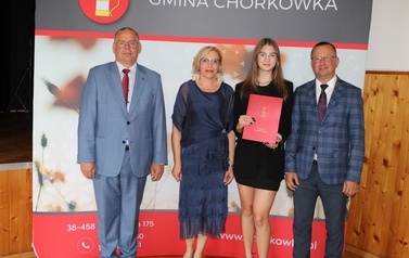 Zdjęcie ucznia z przedstawicielami gminy i dyrektorem. 
