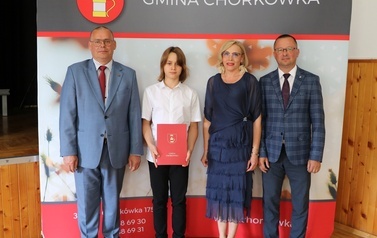 Zdjęcie ucznia z przedstawicielami gminy i dyrektorem. 