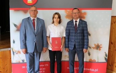 Zdjęcie ucznia z przedstawicielami gminy i dyrektorem. 