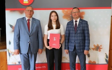Zdjęcie ucznia z przedstawicielami gminy i dyrektorem. 