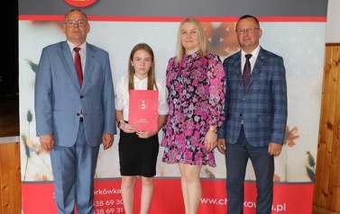 Zdjęcie ucznia z przedstawicielami gminy i dyrektorem. 