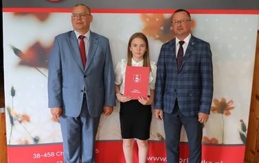 Zdjęcie ucznia z przedstawicielami gminy i dyrektorem. 