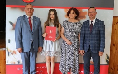 Zdjęcie ucznia z przedstawicielami gminy i dyrektorem. 