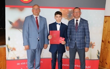 Zdjęcie ucznia z przedstawicielami gminy i dyrektorem. 