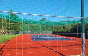 Boisko sportowe w kolorze niebiesko-pomarańczowym.