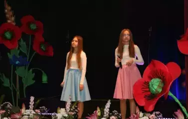 Dwie dziewczynki w białych bluzkach i niebieskiej oraz r&oacute;żowej sp&oacute;dnicy.