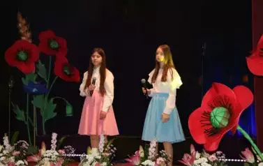 Dwie dziewczynki w białych bluzkach i niebieskiej oraz r&oacute;żowej sp&oacute;dnicy. 