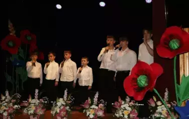 Zdjęcia chłopc&oacute;w śpiewających na scenie. 