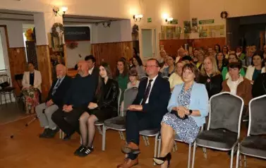 Zdjęcie publiczności, w eleganckich strojach. 