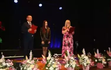 Grupa trzech os&oacute;b, pani dyrektor nagrodzona Amelia Kaszowska i w&oacute;jt gminy Chork&oacute;wka. 