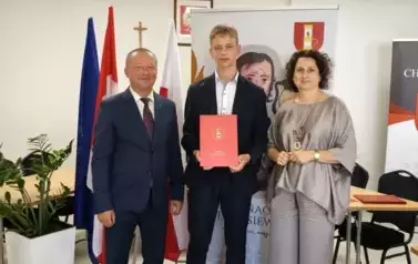 Stypendysta w towarzystw w&oacute;jta i pani dyrektor. Zdjęcie po odebraniu nagrody. 