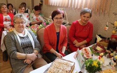 Zdjęcia ukazują bogactwo podkarpackiego folkloru. Członkinie KGW z całej gminy prezentują się w tradycyjnych strojach: białych, haftowanych bluzkach z kryzami oraz charakterystycznych czerwonych koralach. Siedzą przy stołach uginających się od tradycyjnyc