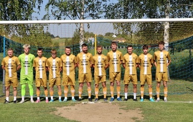 Seria dynamicznych i pozowanych zdjęć z amatorskiego turnieju piłki nożnej, kt&oacute;ry odbył się w pogodny, słoneczny dzień na trawiastym boisku otoczonym brzozami. Zdjęcia przedstawiają pełny przebieg wydarzenia sportowego. Galeria zawiera pozowane fotografie