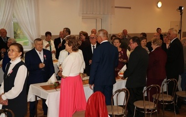 Zdjęcia z uroczystości Złotych God&oacute;w w Domu Ludowym w Zręcinie. Przedstawiają one występy męskiej sekcji Zespołu Śpiewaczego &bdquo;Chorkowianie&rdquo; w tradycyjnych strojach ludowych, oficjalne wystąpienie władz gminy Chork&oacute;wka oraz pamiątkowe kadry z jubilatami odznaczonymi Medalami za Długoletnie Pożycie Małżeńskie.