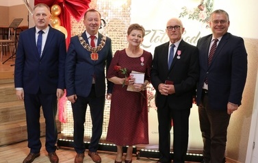 Zdjęcia z uroczystości Złotych God&oacute;w w Domu Ludowym w Zręcinie. Przedstawiają one występy męskiej sekcji Zespołu Śpiewaczego &bdquo;Chorkowianie&rdquo; w tradycyjnych strojach ludowych, oficjalne wystąpienie władz gminy Chork&oacute;wka oraz pamiątkowe kadry z jubilatami odznaczonymi Medalami za Długoletnie Pożycie Małżeńskie.