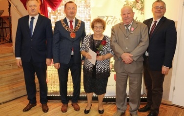 Zdjęcia z uroczystości Złotych God&oacute;w w Domu Ludowym w Zręcinie. Przedstawiają one występy męskiej sekcji Zespołu Śpiewaczego &bdquo;Chorkowianie&rdquo; w tradycyjnych strojach ludowych, oficjalne wystąpienie władz gminy Chork&oacute;wka oraz pamiątkowe kadry z jubilatami odznaczonymi Medalami za Długoletnie Pożycie Małżeńskie.
